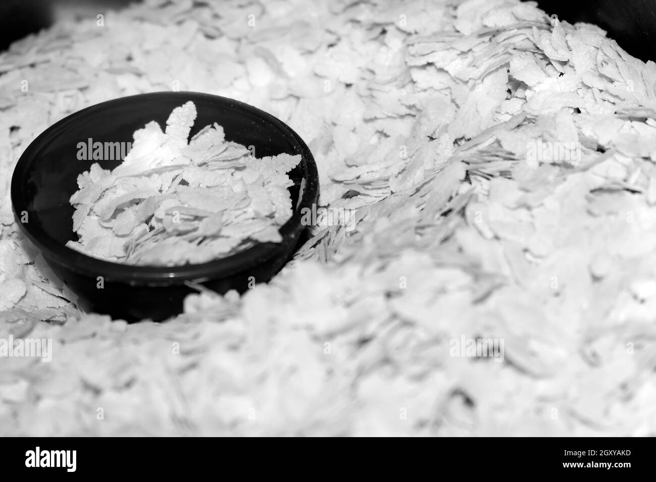Black And White Pounding Paddy `POHA` or Flattened rice, Uncooked puffed rice flakes commonly use in India for breakfast Stock Photo